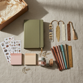 Journaling mystery gift box with journals, pens, stickers, washi tape, and writing accessories